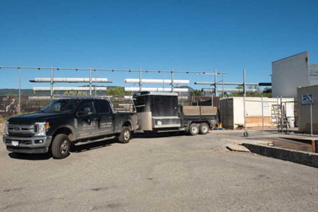 Red lock storage truck pulling trailer coming into lot